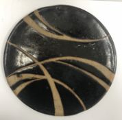 A studio pottery plate in the manner of Soji Hamada, unsigned,
