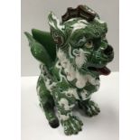 A green ground brown and white relief decorated Dog of Fo figural vase by Manuel Gustavo Bordallo