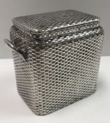 A silver basket weave twin handled container with hinged lid bearing inscription to tie on type