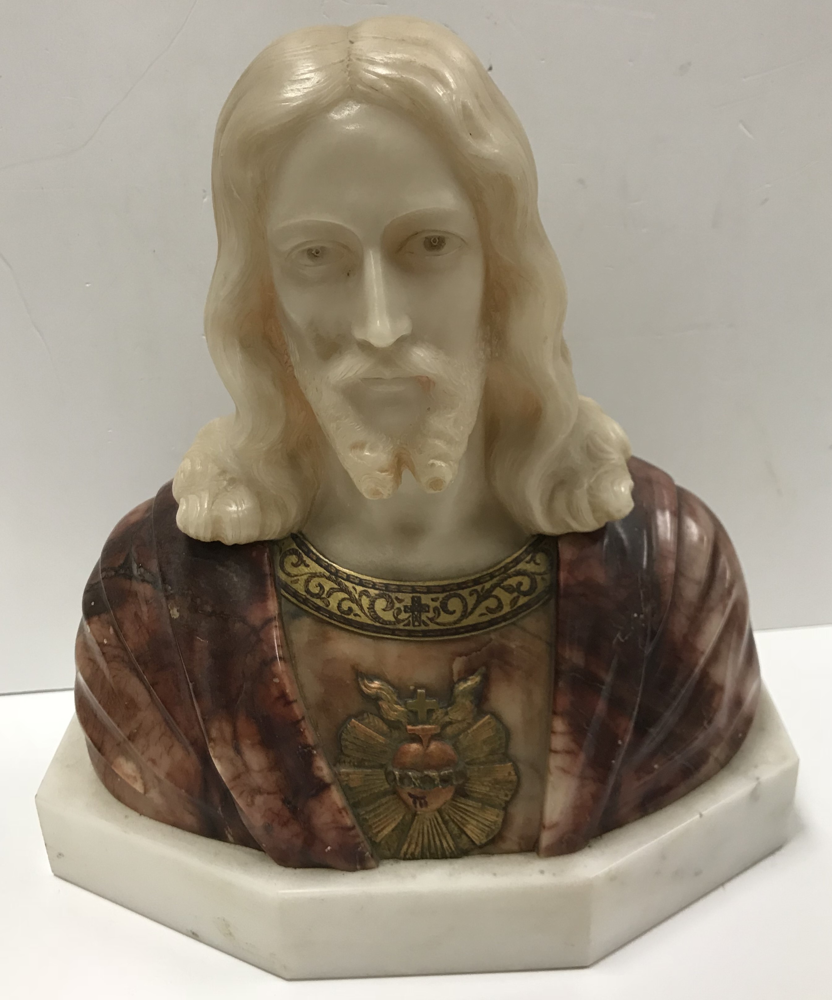 An alabaster carved figural bust of Christ with sacred heart motif at his breast,