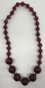 A vintage cherry amber graduated bead necklace, largest beads approx 1.