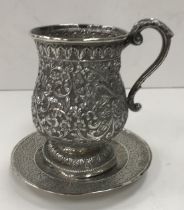 A Burmese white metal floral and foliate embossed baluster shaped mug 11.