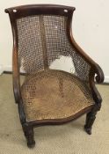 A William IV mahogany framed bérgère chair with scroll back and lotus leaf carved arms on turned