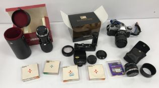 A collection of photographic equipment including an Olympus OM20 35 mm camera,