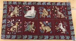 A needlepoint panel set with animal motifs in a tiled design to include leopard, monkey, greyhound,