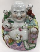 A Chinese polychrome decorated figure of a seated Buddha with five children bearing impressed four