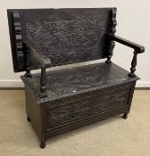 A circa 1900 carved oak monk's bench in the Gothic Revival taste,