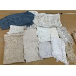 A box containing various early 20th Century vintage crocheted wares to include table covers,