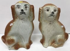 A near matching pair of Sadler type Staffordshire spaniel ornaments with glass eyes (one with eyes