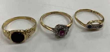 Three 18 carat gold ladies dress rings including a flower head design example with central oval cut