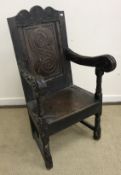 A 17th Century and later oak Wainscott type armchair with carved decoration and panel seat on