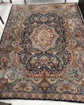 A large Persian rug, the central panel set with floral decorated medallion on a pale pink,