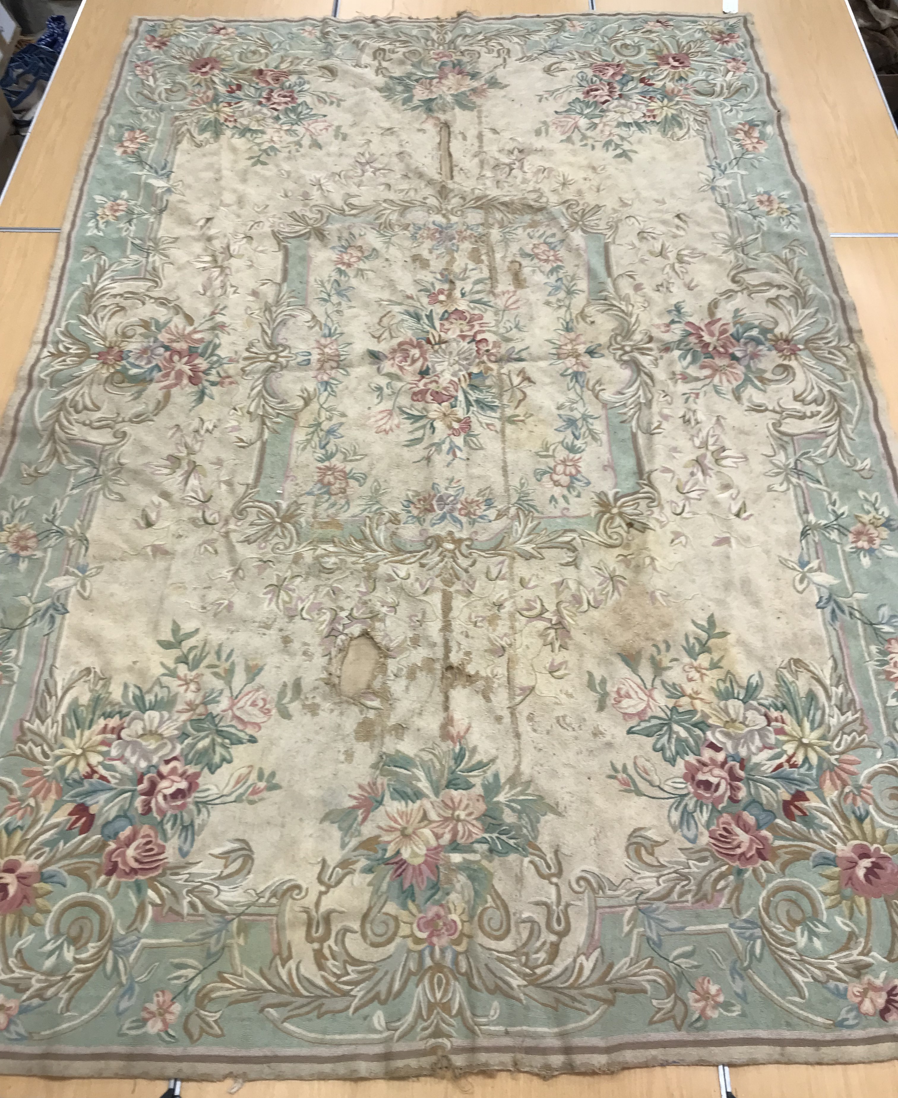 A crewelwork carpet/panel, the cream and green ground set with scrolling foliate design approx.