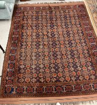A Persian carpet, the central panel set with foliate floral and lozenge medallions on a blue ground,