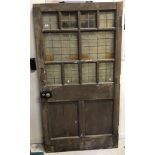 A stained pine framed part leaded glazed door with ten leaded panels over two twin wooden panels