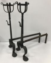 A pair of 20th Century wrought iron fire dogs with integral ale mullers in the Arts and Crafts