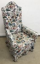 A 19th Century upholstered high back armchair on slender turned tapering front legs to pad feet,