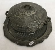 An early 19th Century German heavy embossed pewter tureen and associated plate base bearing pewter