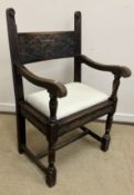 An Arts & Crafts carved oak framed hall chair by Liberty & Co.