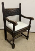 An Arts & Crafts carved oak framed hall chair by Liberty & Co.