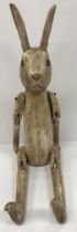 A vintage carved and painted wooden "Hennow hare" figure with jointed arms and legs 48 cm high