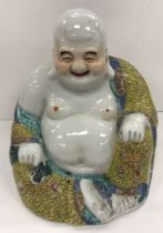 A 19th Century Chinese polychrome decorated figure of a seated Buddha with impressed four character