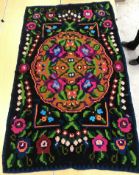 A Kelim rug, the dark brown ground set with neon florals and scrolling foliate design,