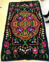 A Kelim rug, the dark brown ground set with neon florals and scrolling foliate design,