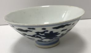 A Ming style Chinese blue and white saucer bowl, the main body decorated with bats amongst clouds,