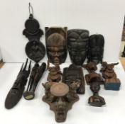 A collection of various African and Eastern carved treenware items including five various masks,