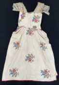 A circa 1920's silk dress with machine embroidered floral bouquets, red edging and lace sleeves,
