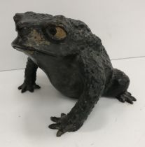 A Meiji period Japanese patinated bronze figure of a toad with gold and black painted eyes 17 cm