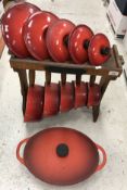 A set of five Le Cruset saucepans and lids in red on stand together with a Cousances cast iron