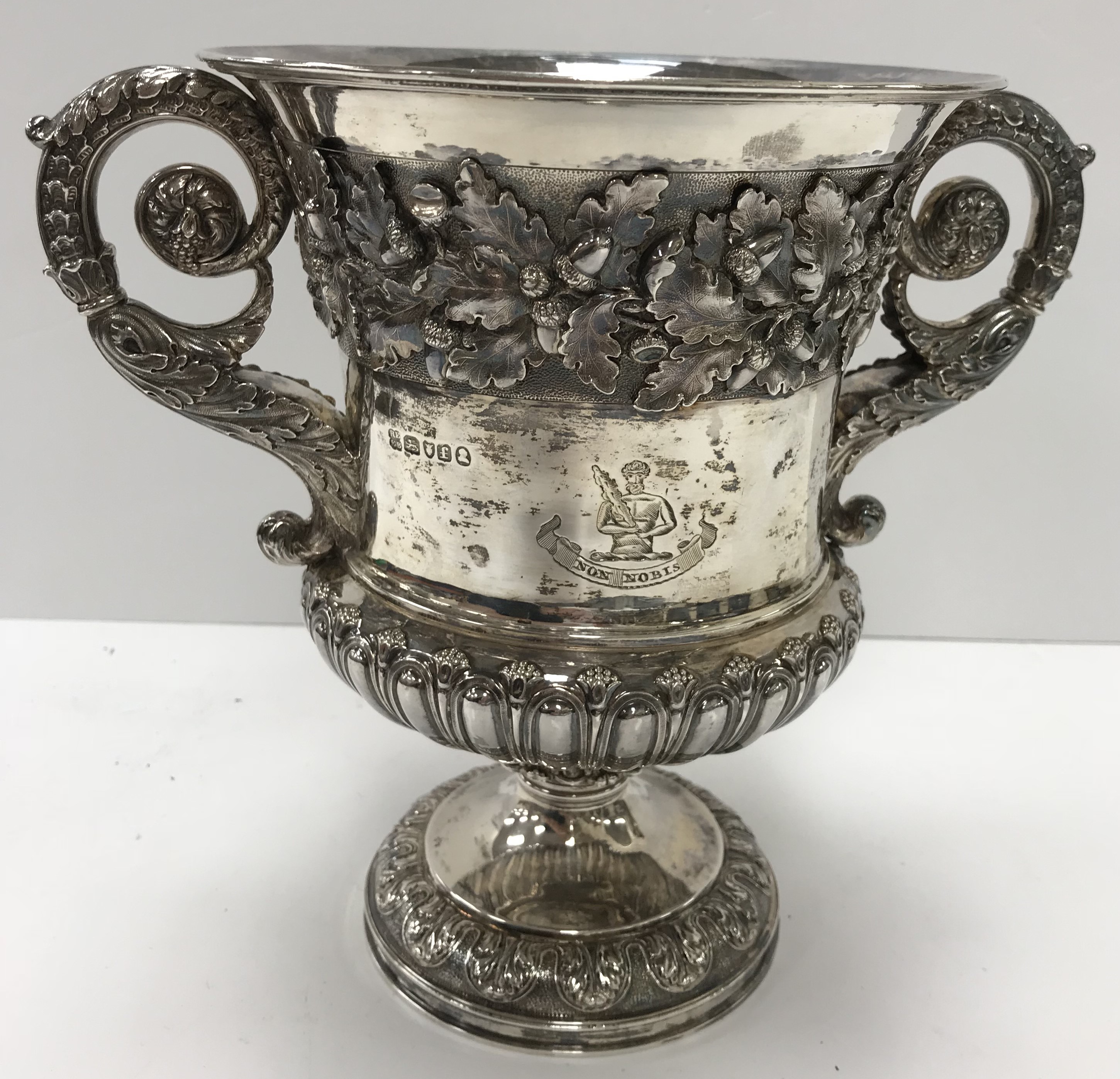 A George IV silver wine cooler with twin handles and oak leaf and acorn decorated band to the top,