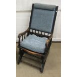 A late Victorian moulded walnut framed and upholstered rocking armchair, 52.