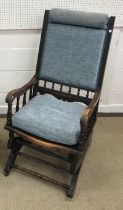 A late Victorian moulded walnut framed and upholstered rocking armchair, 52.