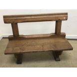 A Victorian oak two seat chapel pew on end trestle supports,