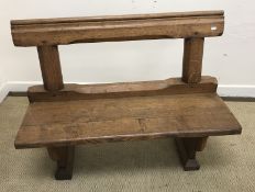 A Victorian oak two seat chapel pew on end trestle supports,