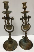 A pair of brass ship's type gimble candlesticks with mounting loops on a circular foot 38 cm high