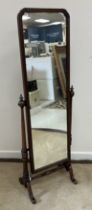 A 20th Century walnut framed cheval mirror in the Georgian style on turned and fluted supports to
