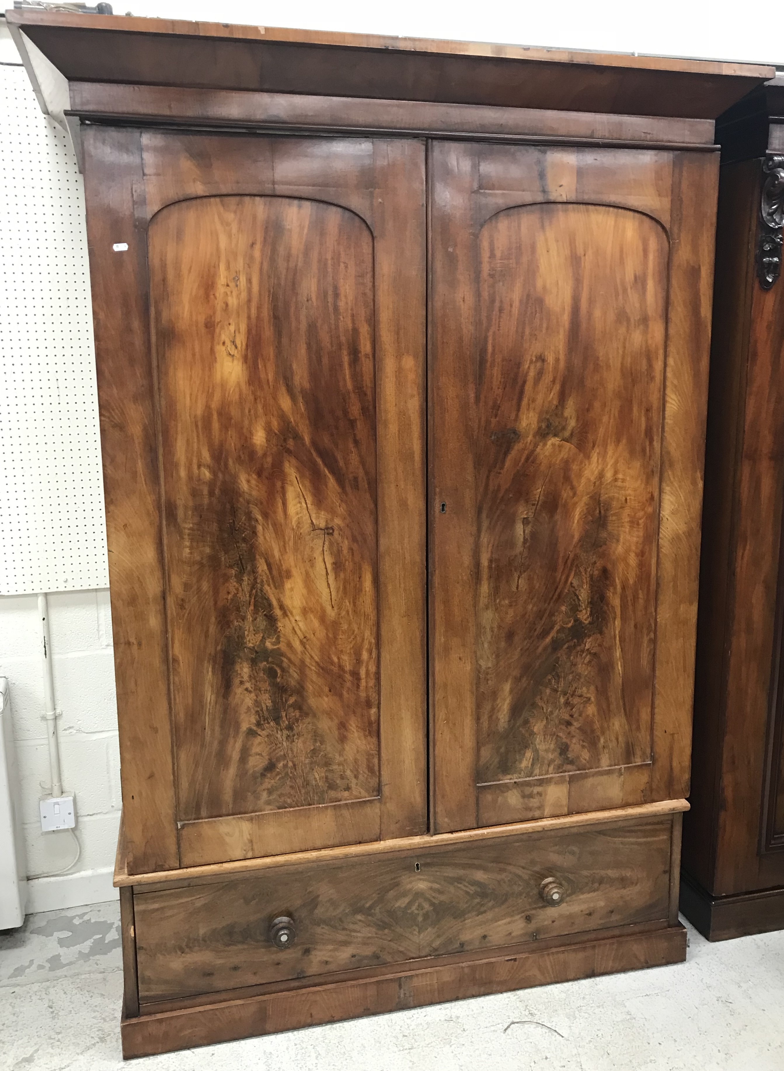 A Victorian mahogany wardrobe, the canted cornice over two panelled doors enclosing a hanging space,