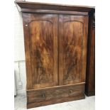 A Victorian mahogany wardrobe, the canted cornice over two panelled doors enclosing a hanging space,