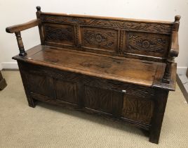 A carved oak hall settle in the 17th Century style,