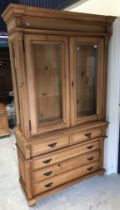 A modern pine china display cabinet with glazed upper section over two short and three long