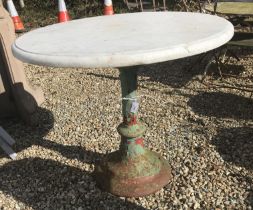 A wrought iron table base with a marble top