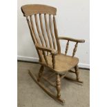A modern stained beech framed slat back rocking armchair in the Victorian style,