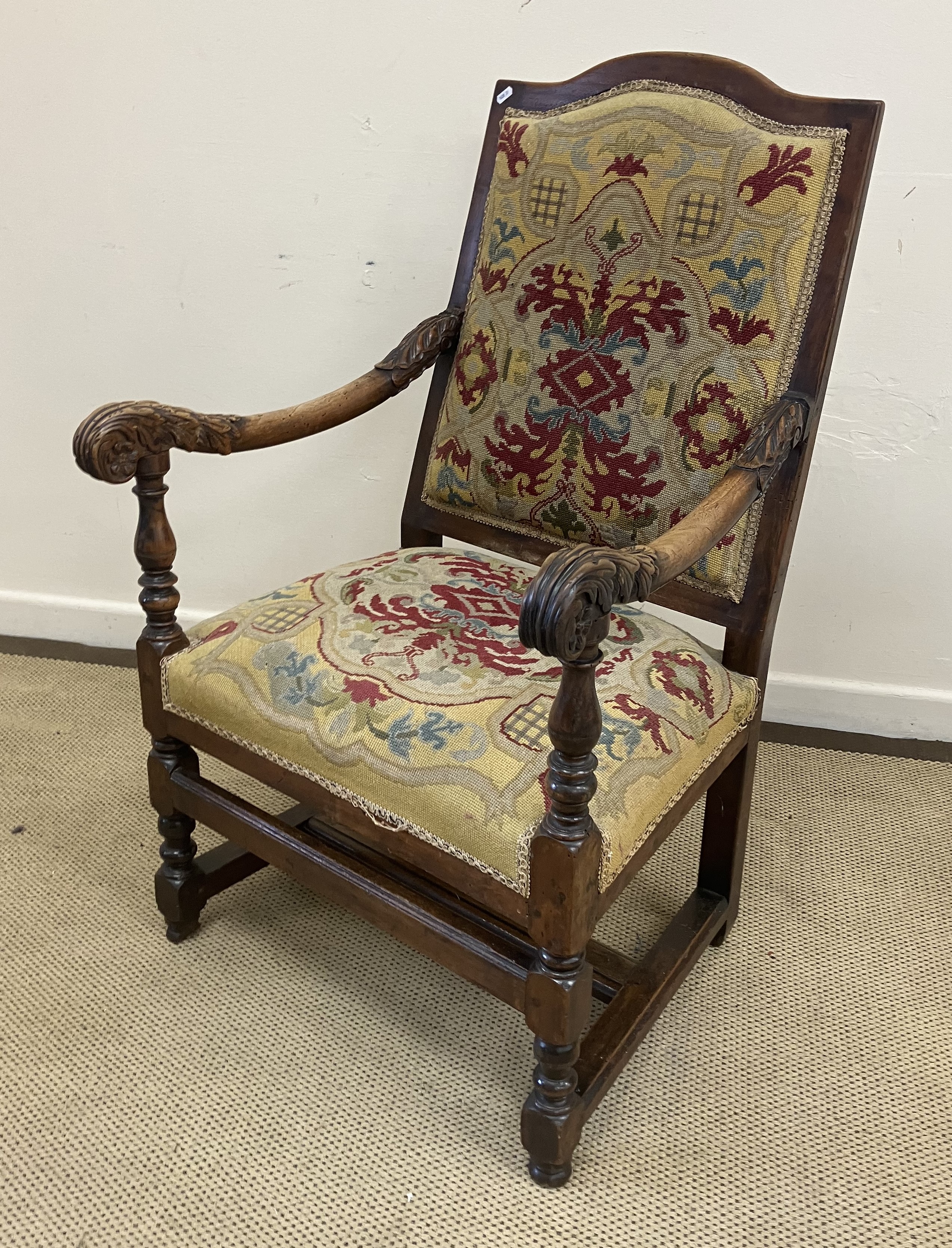 A walnut framed hall chair in the 17th Century Flemish taste with upholstered back and seat flanked