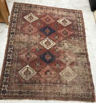 A Caucasian rug, the central panel set with repeating diamond medallions on a red ground,