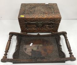 An Indonesian carved camphor wood miniature trunk with all over figural and foliate decoration