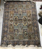 A silk rug, the central panel set with tiled Persian floral design in blues,